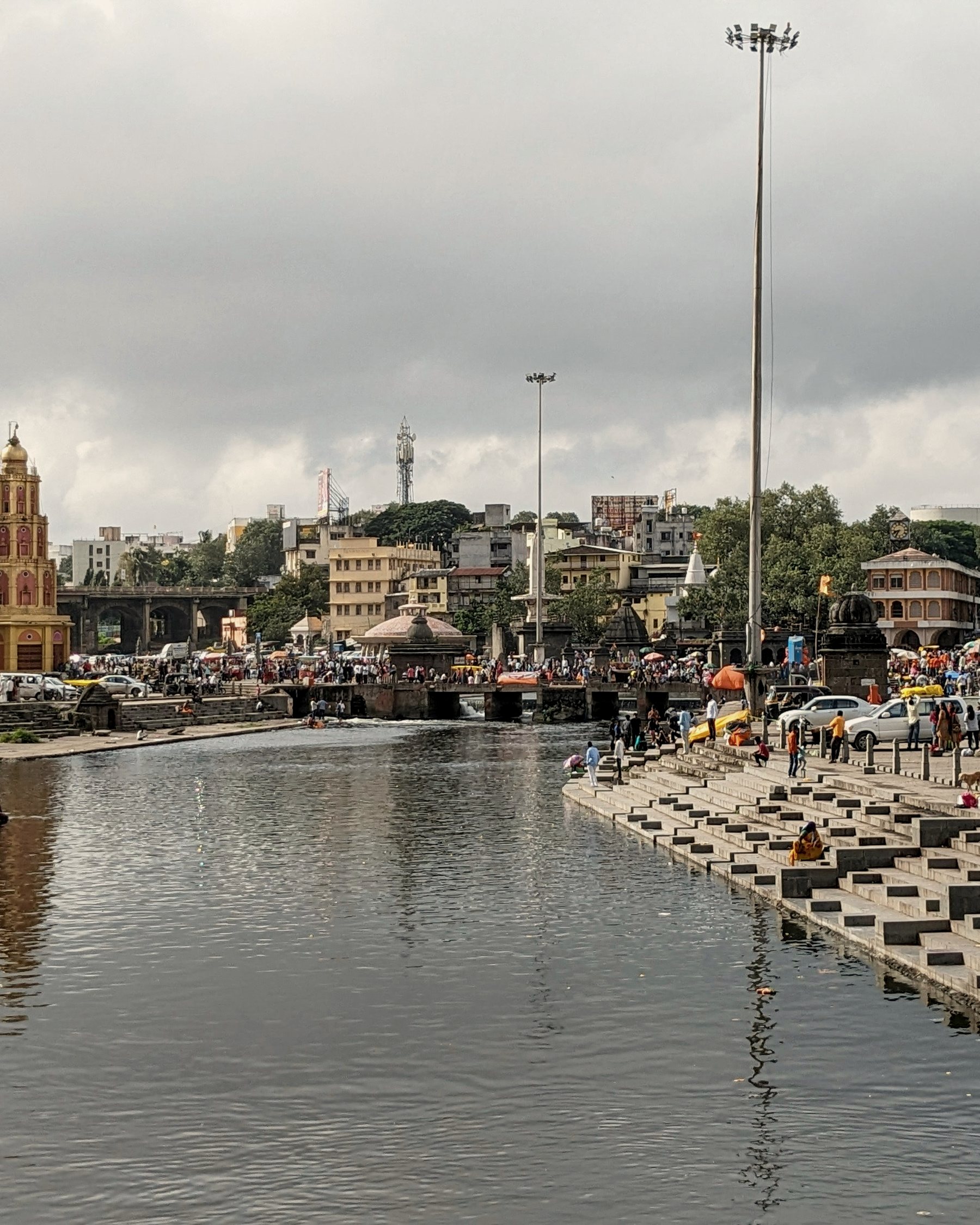 Stone steps down to the river at Nashik, with a temple spire and the old town beyond